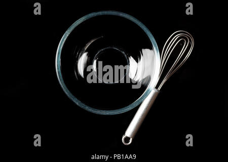 Trasparente come il vetro ciotola con baffo di metallo a parte su sfondo nero direttamente dal di sopra con la riflessione Foto Stock
