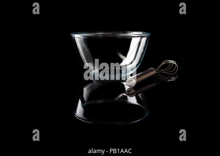 Trasparente come il vetro ciotola con baffo di metallo a parte su sfondo nero in vista laterale con la riflessione Foto Stock