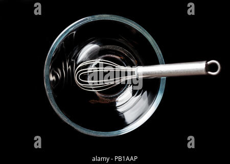 Trasparente come il vetro ciotola con baffo di metallo interno su sfondo nero direttamente da sopra Foto Stock