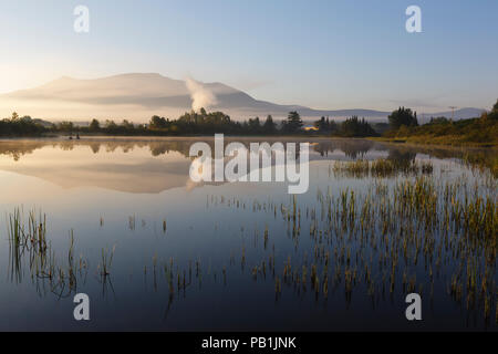 La riflessione di ciliegia Montagna in aeroporto Marsh, vicino a Washington Mt aeroporto regionale, in Whitefield, New Hampshire USA una nebbiosa mattina d'estate. Foto Stock