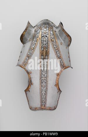 Half-Shaffron (testa di cavallo difesa). Cultura: Italiano, probabilmente a Milano. Dimensioni: H. 15 1/4 in. (38,7 cm); W. 10 3/4 in. (27,3 cm); D. 7. (17,8 cm); Wt. 2 lb. 11 oz. (1208 g). Data: ca. 1570-80. Questo shaffron corrisponde un italiano di armor per l uomo nel Metropolitan Museum (acc. n. 14.25.717) che è oggi montato a cavallo come parte del gruppo equestre nella hall principale delle armi e armature gallerie. Le bande sottili incisi con trofei di armi, vasi, uccelli e creature grottesche su una linea a punto e annerite sono di massa tipica decorazione per armatura italiana del periodo. Il shaffron Foto Stock