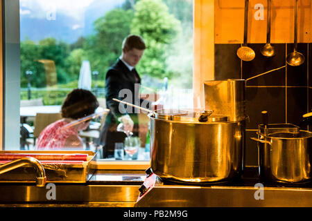 Hotel Lenkerhof, Lenk, Svizzera. Mentre sulla terrazza è giunto il momento per l'Apéro, nella cucina mediterranea della 'Oh de vie' la pentola di cottura è già pronta per i primi ordini di pasta Foto Stock