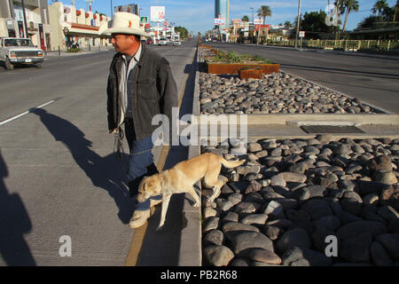 Nazioni Unite hombre con la vestimenta vaquera de la regione camina por la zona hotelera de Hermosillo, el Bulevar kino ............................... Foto Stock