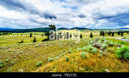 Nuvole scure appesa sopra le fertili terreni coltivati e colline lungo l'autostrada 5A nei pressi di Nicola Lago, tra Kamloops e Merritt nella regione Okanagen Foto Stock