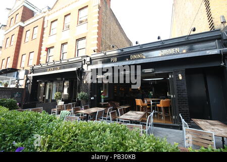 I residenti si riuniscono in Leone Nero pub dopo un incendio scoppiato in un blocco di appartamenti sulla strada di Inglewood, a nord ovest di Londra, dove 100 vigili del fuoco sono stati chiamati a mettere fuori il blaze. Foto Stock