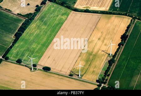 Burgdorf, Germania. Xxv Luglio, 2018. Tre turbine eoliche sono in piedi nel centro di grano raccolto i campi (fotografati da un aliante). Credito: Hauke-Christian Dittrich/dpa/Alamy Live News Foto Stock