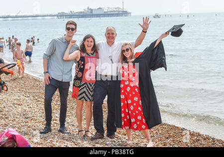 Brighton Regno Unito 26 luglio 2018 - Melissa Jensen non si raffredda con una racchetta con la sua famiglia sulla spiaggia di Brighton dopo essersi laureato presso la Sussex University come l'ondata di caldo condizioni continuano sulla costa sud di oggi dovrebbe essere il giorno più caldo dell'anno finora in alcune parti della Gran Bretagna Credito: Simon Dack/Alamy Live News Foto Stock