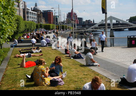 Glasgow, Regno Unito, 26 luglio 2018, meteo UK, persone di Glasgow godere ancora un altro giorno di calore. La folla si raccolgono lungo il fiume Clyde sul Broomielaw quay durante l'ora di pranzo a prendere il sole mentre essa dura. Credito: Pawel Pietraszewski / Alamy Live News Foto Stock