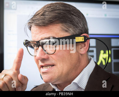 26 luglio 2018, Germania, Darmstadt: Boris Rhein, Hessian Ministro della scienza (R, CDU), utilizza vetri che utilizza la realtà aumentata per fornire informazioni per il flusso di processo per la produzione di una pompa pneumatica durante la sua visita al processo CiP controller factory dell'Università Tecnica di Darmstadt. La tecnologia di processo Factory è un corso di formazione e perfezionamento professionale centro che sviluppa metodi per migliorare i processi di produzione in aziende di medie dimensioni e industria. Foto: Frank Rumpenhorst/dpa Foto Stock