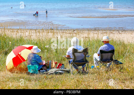 Troon, Ayrshire. Il 26 luglio 2018. Regno Unito: Meteo molti usufruire dell'insolitamente caldo e prendere per la spiaggia a raffreddarsi, prendere il sole o fare una nuotata in mare. Alan Clark, Heather Clark e Helen Feasey da Lanark percorsa a Troon spiaggia e ha trovato un posto abbastanza per un picnic Credito: Findlay/Alamy Live News Foto Stock