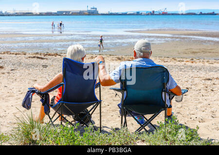 Troon, Ayrshire. Il 26 luglio 2018. Regno Unito: Meteo molti usufruire dell'insolitamente caldo e prendere per la spiaggia a raffreddarsi, prendere il sole o fare una nuotata in mare. Robert e Maureen Ballantyne da Glasgow Godetevi tutto un posto sulla spiaggia e a fare un po' di credito per prendere il sole: Findlay/Alamy Live News Foto Stock