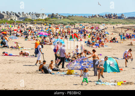 Troon, Ayrshire. Il 26 luglio 2018. Regno Unito: Meteo molti usufruire dell'insolitamente caldo e prendere per la spiaggia a raffreddarsi, prendere il sole o fare una nuotata in mare. Credito: Findlay/Alamy Live News Foto Stock