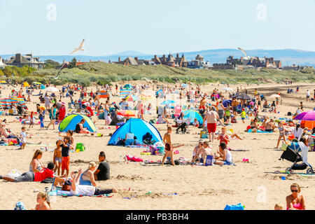 Troon, Ayrshire. Il 26 luglio 2018. Regno Unito: Meteo molti usufruire dell'insolitamente caldo e prendere per la spiaggia a raffreddarsi, prendere il sole o fare una nuotata in mare. Credito: Findlay/Alamy Live News Foto Stock