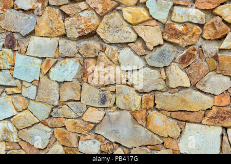 Decorativi in pietra a parete, pezzi di roccia legati con cemento. Texture ciottoli con crepe. Monte Castello di San Juan. Lo spagnolo beach resort Blanes in summ Foto Stock