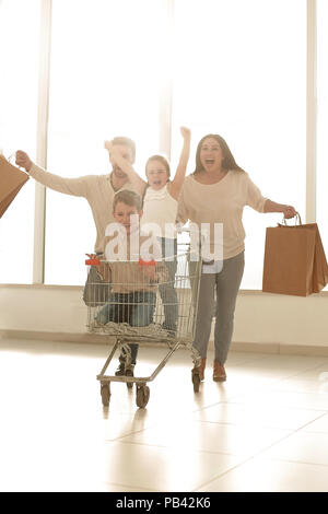 La famiglia felice con carrello e i bambini Foto Stock