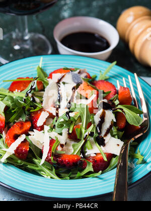 Con insalata di fragole, rucola e parmigiano spruzzata con glassa di aceto balsamico Foto Stock