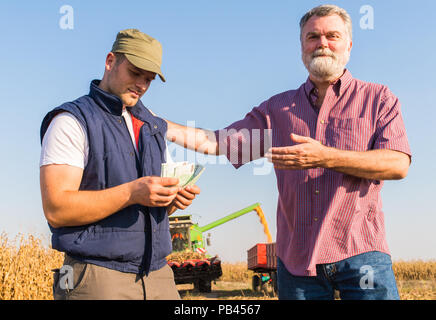 Felice agricoltore dopo il raccolto di mais Foto Stock