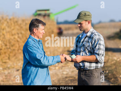Felice giovane agricoltore dopo il raccolto di mais Foto Stock