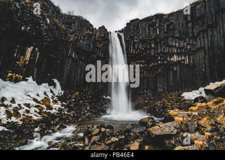 Drammatica vista la mattina del famoso Svartifoss (nero caduta) cascata. Estate colorato sunrise in Skaftafell, Vatnajokull National Park, l'Islanda, l'Europa. Stile artistico post elaborati foto. Foto Stock