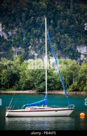 Una imbarcazione a vela è visto in il Walensee vicino a Weesen, ancorato solo off shore. Foto Stock