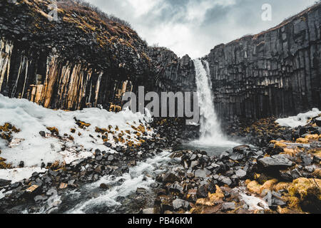 Drammatica vista la mattina del famoso Svartifoss (nero caduta) cascata. Estate colorato sunrise in Skaftafell, Vatnajokull National Park, l'Islanda, l'Europa. Stile artistico post elaborati foto. Foto Stock