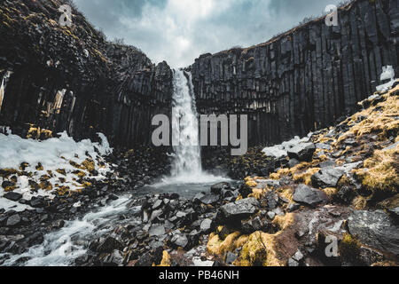 Drammatica vista la mattina del famoso Svartifoss (nero caduta) cascata. Estate colorato sunrise in Skaftafell, Vatnajokull National Park, l'Islanda, l'Europa. Stile artistico post elaborati foto. Foto Stock