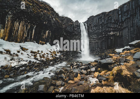 Drammatica vista la mattina del famoso Svartifoss (nero caduta) cascata. Estate colorato sunrise in Skaftafell, Vatnajokull National Park, l'Islanda, l'Europa. Stile artistico post elaborati foto. Foto Stock