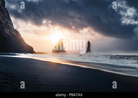 Alba alla famosa spiaggia di sabbia nera Reynisfjara in Islanda. Windy mattina. Le onde del mare. Cielo colorati. Mattina al tramonto. Foto Stock