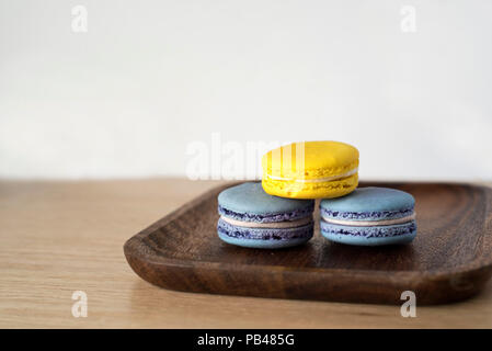 Giallo e Blu di Macaron torre sul piatto di legno Foto Stock