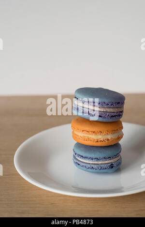 Pila di amaretti francese / Macarons in blu e arancione, una golosa e spuntino zuccherino Foto Stock