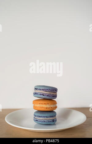 Amaretti impilati rendendo un blu e arancione di sandwich delizioso proporzioni - Set di tre Foto Stock