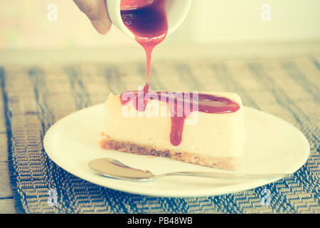 Effetto vintage stile di versare la salsa in cheesecake Foto Stock