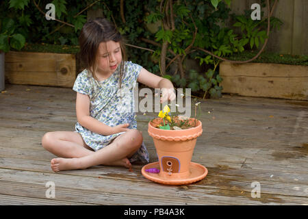 Giovane ragazza che gioca con il suo giardino di fata Foto Stock