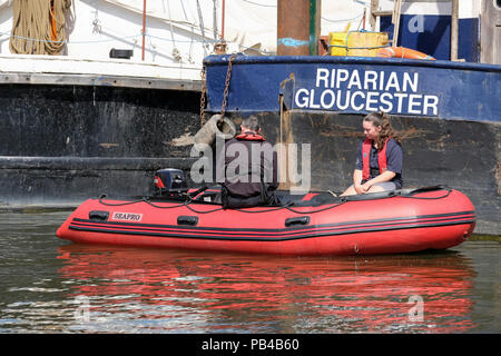 Canal draga rivierasche ormeggiata in Gloucester docks. Barca di sicurezza accanto a. Foto Stock