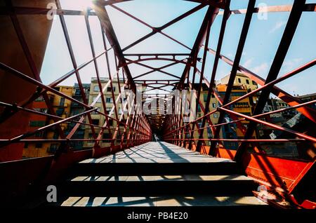 Case colorate visto attraverso il rosso ponte in ferro in Girona, in Catalogna, Spagna Foto Stock