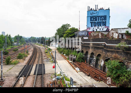 Vista la ferrovia dal ponte di Kentish Town, Londra, Regno Unito, con un grande cartello blu lettura "Benvenuto a Kentish Town' Foto Stock