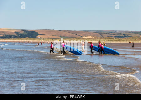 Un gruppo femminile di surfers prendendo lezioni in mare a Condino, Devon, Regno Unito Foto Stock