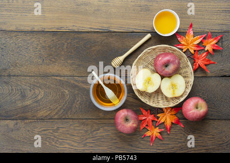 Table top visualizza immagine aerea di decorazione raccolto autunnale o Rosh Hashanah giorno concetto di sfondo.piatto apple laici slice & honey bee con maple lasciare su mo Foto Stock