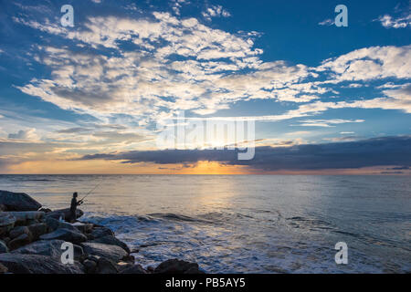 I pescatori stagliano contro un Cielo di tramonto sul Golfo del Messico sul molo nord in Nokomis Florida Foto Stock