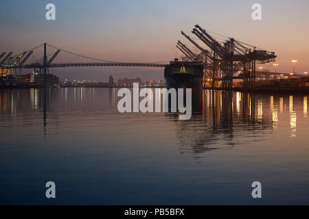 Il Gigante evergreen nave portacontainer, inviato mai si diparte la EVERPORT terminale per container nel porto di Los Angeles all'alba. In California, Stati Uniti d'America. Foto Stock