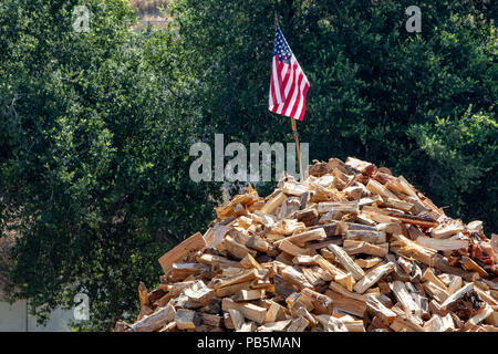 Una bandiera americana sulla sommità di una grande catasta di legna da ardere. Foto Stock