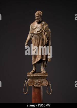 Statuetta in bronzo di un filosofo su un supporto della lampada. Cultura: Romano. Dimensioni: complessivo: 10 3/4 in., 2.9kg (27.3 cm, 6.4lb.). Data: fine del I secolo A.C. Adattamento di una statua greca del III secolo A.C. Sormontato da un ritratto della statuetta un filosofo. Questa statuetta è una copia ridotta di un originale ellenistico del III secolo A.C. Museo: Metropolitan Museum of Art di New York, Stati Uniti d'America. Foto Stock