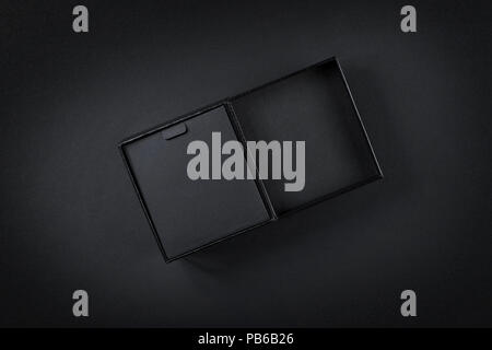 Scatola di cartone nero vista dall'alto su nero. Tasto basso studio shoot Foto Stock