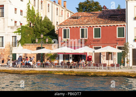 Le persone aventi aperitivi serali, bar de Matteo, isola della Giudecca, Venezia, Veneto, Italia si affaccia sul Canale della Giudecca al tramonto Foto Stock