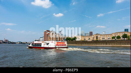 City Cruises barche turistiche illenium "Alba" conduce i passeggeri lungo il fiume Tamigi passato l'Isle of Dogs; Canary Wharf in background. Foto Stock