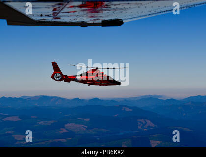 Un U.S. Coast Guard HH-65 Dolphin intercetta un Cessna 182 Skylane durante tre giorni di controllo aerospaziale Alert CrossTell live-fly esercitazione a Portland Air National Guard Base, Ore., 26 luglio 2018. I rappresentanti della Air National Guard fighter ali, Civil Air Patrol, E DEGLI STATI UNITI Coast Guard ad ala rotante intercettano aria unità verranno effettuare giornalmente sortite da luglio 24-27 per perfezionare le loro competenze a livello tattico aria-intercettare le procedure. (U.S. Air National Guard foto di Senior Airman Timoteo Tweet) Foto Stock