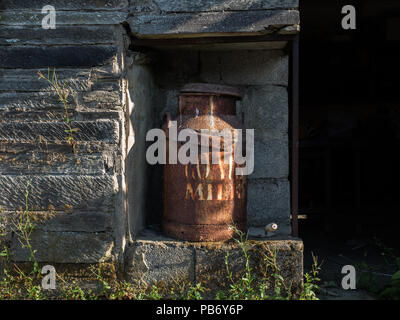 Rusty capre bidone di latte nel fienile Foto Stock