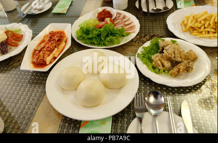 Tipico pasto servito ai turisti per la Corea del Nord in un turista solo ristorante, compresi kimchi Foto Stock