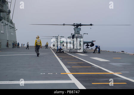 180723-N-VR594-2504 in mare (luglio 23, 2018) AH-1Z Cobras e UH-1Y Hueys, entrambi assegnati alla 'Scarface' di Marine Attacco leggero elicottero Squadron (HMLA) 367, condotta deck qualifiche di atterraggio sul ponte di volo della Royal Australian Navy atterraggio elicottero nave dock HMAS Adelaide (L01) durante il cerchio del Pacifico (RIMPAC) Esercizio, 23 luglio. Questa è la prima volta Adelaide ha condotto le operazioni di volo con Marine AH-1Z Cobras e UH-1Hueys y. Venticinque nazioni, 46 navi, cinque sommergibili, circa 200 aerei, e 25.000 personale partecipano RIMPAC dal 27 giugno al 2 agosto in Foto Stock