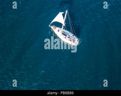 Lonely yacht isolato sotto la vela con altezza montante andando ancora in mare antenna vista superiore Foto Stock